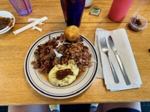 A table displays a plate of food, a drink, and a fork, inviting a pleasant dining experience.