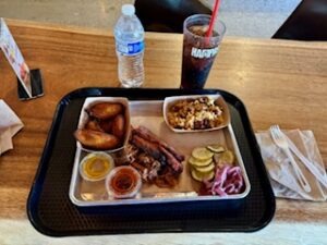 A tray filled with various food items and drinks placed on a wooden table.